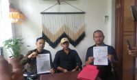 Penasihat Hukum I Wayan Gede Mardika, S.H., M.H., (kanan) dan Dewa Nyoman Wiesdya Danabrata Parsana, S.H., S.E., (kiri) dari LBH Paiketan Krama Bali mendampingi putra korban Made Alit Putra (tengah) saat memberikan keterangan pers, di Denpasar, Minggu (16/10/2022). (Agus Pebriana/Diksimerdeka.com)