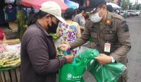 Personel Satpol PP Provinsi Bali saat membagikan tas ramah lingkungan, Rabu (2/11) pagi. (Foto: Humas Pemprov Bali)