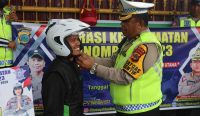 Satgas Operasi Keselamatan Tinombala 2023 Polda Sulteng memberikan helm gratis kepada salah satu pengendara yang tertib berlalu lintas, Selasa (14/02/23). (Rahmad/diksimerdeka.com)