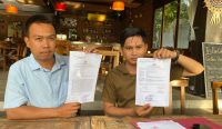 I Made Dwi Atmiko Aristianto (kanan) bersama I Made Juanda Aditya, keponakan Nyoman Liang saat menunjukkan Laporan Polisi terkait dugaan pengerusakan pagar di atas lahan di jalan Badak Agung Denpasar. Foto: dok/ist