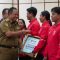 Pj Gubernur Bali Sang Made Mahendra Menyerahkan bonus kepada atlet berprestasi di PON XXI, Senin (17/02/2025). Foto: dok/Pemprov Bali