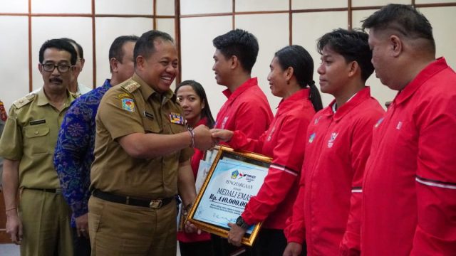 Pj Gubernur Bali Sang Made Mahendra Menyerahkan bonus kepada atlet berprestasi di PON XXI, Senin (17/02/2025). Foto: dok/Pemprov Bali