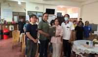 Ketua Tim Pengabdian Masyarakat Fakultas Farmasi Unmas Denpasar, apt. Nyoman Budiartha Siada, S.Farm., M.Farm. menyerahkan cendera mata secara simbolis kepada Ketua Yayasan Pendidikan Dria Raba, Ir. Ida Ayu Pradnyani Manthara, disaksikan oleh mahasiswa dan peserta kegiatan edukasi.