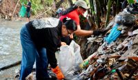 Duta Pengelolaan Sampah Berbasis Sumber (PSBS) Pelemahan Kedas (PADAS), Putri Suastini Koster tengah membersihkan aliran sungai di perbatasan Desa Dauh Peken dan Delod Peken, Tabanan, Minggu (8/6/2025). Foto: dok/Pemprov Bali