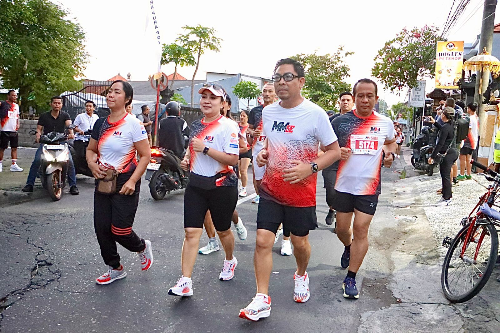 Wakil Wali Kota Denpasar, I Kadek Agus Arya Wibawa, didampingi panitia, mengibaskan bendera start sebagai tanda dimulainya MM Fun Run 2025 kategori 10K di Lapangan GOR Ida Cokorda Ngurah Gede Pemecutan, Minggu (29/6) pagi. Event ini diikuti ratusan pelari dari berbagai kalangan. Foto: tim/diksimerdeka.com