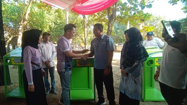 Bupati Jember menyerahkan tempat sampah daur ulang secara simbolis kepada perwakilan masyarakat dalam kegiatan Bunga Desaku di kawasan wisata Watu Ulo, Ambulu, Minggu (27/7/2025).