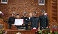 Wakil Wali Kota Denpasar I Kadek Agus Arya Wibawa (kiri) bersama Ketua DPRD Kota Denpasar I Gusti Ngurah Gede (kedua dari kiri), Wakil Ketua DPRD I Wayan Mariyana Wandhira (kedua dari kanan), dan Made Oka Cahyadi Wiguna (kanan) menunjukkan dokumen RPJMD 2025-2029 yang telah disahkan dalam Rapat Paripurna ke-18 DPRD Kota Denpasar, Kamis (3/7/2025). Foto: tim/diksimerdeka.com