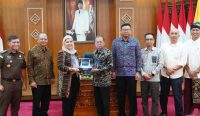 Gubernur Bali Wayan Koster menerima cinderamata dari EVP Kontruksi PT PLN, Ratnasari Sjamsudin, usai rapat dukungan proyek Sutet 500kV Gilimanuk–Antosari di Jaya Sabha, Denpasar, Rabu (23/7/2025).