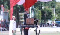 Bupati Jember, Muhammad Fawait, mengenakan busana adat Nusantara dipadukan selendang Palestina saat memimpin upacara HUT RI ke-80 di Alun-alun Jember, Minggu (17/8/2025).