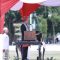 Bupati Jember, Muhammad Fawait, mengenakan busana adat Nusantara dipadukan selendang Palestina saat memimpin upacara HUT RI ke-80 di Alun-alun Jember, Minggu (17/8/2025).