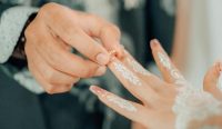 Prosesi pemasangan cincin pernikahan pada pengantin wanita dalam acara pernikahan