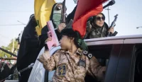 Anak kecil membawa pistol mainan dalam parade militer Iran di Tehran