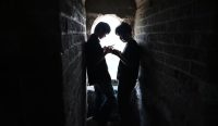 Dua pemuda melihat ponsel di menara pengawas Tembok Besar China kawasan Badaling saat libur nasional Hari Buruh di Beijing.