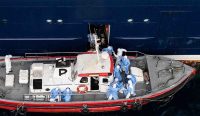 Petugas kesehatan membantu pasien turun ke perahu dari kapal pesiar MV Hondius pada 6 Mei 2026 di tengah wabah hantavirus.