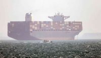 Kapal kontainer berbendera Iran Hamouna berlabuh di Selat Hormuz saat sebuah perahu motor kecil melintas di tengah meningkatnya ketegangan antara Iran dan Amerika Serikat.