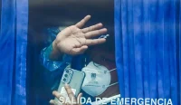 Penumpang MV Hondius melambaikan tangan dari bus militer setelah dievakuasi ke Tenerife, Spanyol, akibat wabah hantavirus.
