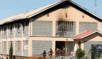 Petugas keamanan berjaga di depan asrama yang rusak akibat kebakaran di Utumishi Girls Academy, Gilgil, Kenya.