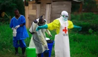 Petugas kesehatan menyemprotkan disinfektan kepada rekannya usai bekerja di pusat perawatan Ebola di Kongo timur.