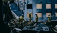 Petugas penyelamat membersihkan puing-puing di dalam Museum Nasional Chornobyl yang rusak akibat serangan rudal Rusia di Kyiv, Ukraina.