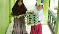 Siswa SD di Kabupaten Bogor, Jawa Barat membawa wadah makanan program Makan Bergizi Gratis (MBG) dari BGN.