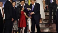 Donald Trump menerima buket bunga dari seorang anak perempuan saat tiba di Beijing, didampingi Wakil Presiden China Han Zheng.