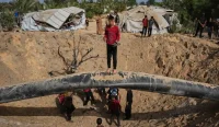 Warga Palestina memeriksa puing-puing bangunan yang hancur akibat serangan udara Israel di Khan Younis, Jalur Gaza selatan.