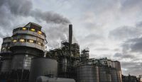 Asap mengepul dari cerobong fasilitas industri di tengah isu emisi karbon dan pemanfaatan energi panas buangan untuk energi terbarukan.