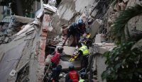 Gempa Venezuela - Petugas penyelamat mengevakuasi korban menggunakan tandu dari gedung yang runtuh akibat gempa Magnitudo 7,5 di Caracas.