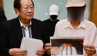 Michael Chong (kiri) mendampingi ayah tersangka dalam konferensi pers terkait kasus dugaan rekayasa penculikan yang dilakukan seorang pengemudi Grab di Malaysia. Foto: The Star.