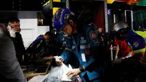 Kebakaran Bangkok memperlihatkan petugas penyelamat Thailand mengevakuasi barang-barang milik korban di lokasi pub yang terbakar di kawasan Chatuchak.