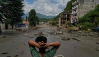 Tatapan kosong seorang anak menyaksikan puing-puing kehancuran total yang disisakan oleh amukan banjir bandang di sepanjang bantaran Sungai Trishuli.