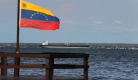 Kibaran bendera kebangsaan berlatar kapal tanker raksasa di Maracaibo, menjadi saksi bisu ironi perampasan hak atas Kendali Minyak Venezuela oleh Amerika Serikat.