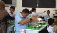Kepala BGN Sudaryono memeriksa makanan Program Makan Bergizi Gratis saat kunjungan ke SDN Bantarjati 09 Bogor.