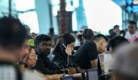 Lautan penumpang mengantre panjang dan berdesakan di konter check-in saat momen Bandara Soekarno Hatta Buka Lagi. Sebelumnya, ratusan penerbangan dibatalkan secara sepihak akibat sebaran abu vulkanik Gunung Anak Krakatau. (Kredit Foto: Faisal Ramadhan/EPA)