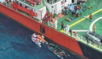 Tim SAR gabungan melakukan proses pengangkatan korban KM Virgo Transport 8 dari perahu karet ke geladak kapal utama di perairan Laut Jawa. Tampak petugas mengenakan APD putih mengevakuasi kantong jenazah menggunakan derek kapal. (Foto: BASARNAS)
