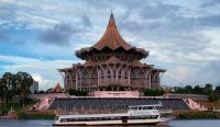 Kemegahan Gedung Dewan Undangan Negeri (DUN) Sarawak dan aktivitas pariwisata Sarawak River Cruise yang kini terancam lumpuh dan merugi akibat kiriman Kabut Asap Indonesia. (Kredit Foto: Masrur Rahman/Unsplash)