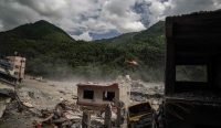 Helikopter penyelamat terbang memantau puing-puing bangunan dan reruntuhan di distrik Betrawati yang hancur total diterjang banjir bandang Nepal akibat krisis iklim dan gletser runtuh. Foto: Ahmer Khan/The Guardian