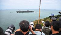 Barisan jurnalis mengabadikan kedatangan kapal induk USS Abraham Lincoln di perairan Pelabuhan Laem Chabang, Pattaya, setelah 270 hari melaut.