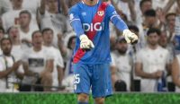 Foto Emil Audero, penjaga gawang utama Rayo Vallecano, beraksi di lapangan dengan seragam kiper biru dan sarung tangan, siap menghalau bola. Latar belakang penonton lawan berbaju putih di stadion selama pertandingan. [Kredit Foto: Facebook/ Rayo Vallecano]. [Kata Kunci: Emil Audero, Rayo Vallecano, Penjaga Gawang, La Liga].