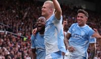 Erling Haaland merayakan gol kontroversialnya bersama rekan setimnya di Derbi Manchester, sebuah momen krusial yang menjadi sorotan utama dalam ulasan Prediksi Manchester City vs Norwich City. Kredit Foto: Catherine Ivill/AMA/Getty Images.
