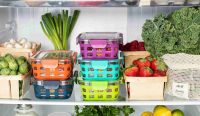 Susunan wadah kedap udara kaca dengan pelindung silikon warna-warni yang tertata rapi di rak untuk menyimpan makanan sisa di kulkas bersama buah dan sayur segar guna mencegah bakteri. (Foto: Ello/Unsplash)