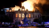 Foto malam hari menunjukkan kobaran api besar melalap bagian atap dan lantai atas Balai Kota Limoges yang bersejarah saat kerusuhan Prancis pecah. Petugas pemadam kebakaran berusaha memadamkan api. Kredit: Pascal Lachenaud/AFP/Getty Images. Keyword: Kerusuhan Prancis.