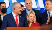 Benjamin Netanyahu berdiri di podium bersama istrinya dan pendukung Partai Likud pada malam Pemilu Israel di Yerusalem, di mana koalisinya gagal merah mayoritas. (Foto: Alexi J Rosenfeld/Getty Images)
