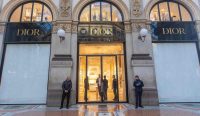 Petugas keamanan berjaga di depan butik Dior yang menutup rapat jendela etalasenya di Galleria Vittorio Emanuele akibat Kerusuhan Milan. Foto: Stefano Porta/LaPresse/Shutterstock.