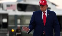 Presiden AS Donald Trump berjalan berlatar helikopter usai mengumumkan kebijakan penangguhan sanksi rusia yang memicu protes Kongres. (Kredit Foto: Eric Lee/Getty Images)