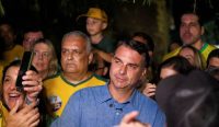 Flávio Bolsonaro mengenakan kemeja biru dikerumuni para pendukungnya usai meraih 47 persen suara dalam perhelatan Pilpres Brasil, mengungguli petahana Luiz Inácio Lula da Silva. (Kredit Foto: Diego Herculano/Reuters)