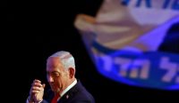 Perdana Menteri Benjamin Netanyahu tampak menangkupkan kedua tangannya ke arah pendukung setelah koalisi sayap kanannya diproyeksikan kehilangan kursi mayoritas pada Pemilu Israel. (Foto: Jalaa Marey/AFP/Getty Images)