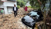 Sebuah mobil hitam tertimbun bebatuan dan material lumpur akibat terjangan Banjir Bandang Phuket usai hujan ekstrem 117mm melanda kawasan Patong. (Foto: THE STANDARD)