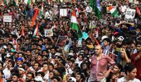 Ribuan massa pemuda dari Gerakan Kecoak India membawa bendera nasional dan poster saat menggelar unjuk rasa menolak penghapusan jutaan hak pilih di Mumbai. (Foto: Indranil Mukherjee/AFP/Getty Images)