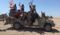 Belasan pejuang Brigade Raksasa Selatan Yaman (Southern Giants Brigades) bersenjata lengkap merayakan dan mengayunkan senapan mereka di atas truk pikap di tengah gurun, yang menandai babak baru Konflik Yaman. Kredit: Yemen Giants Brigades Media Centre/AFP/Getty Images.